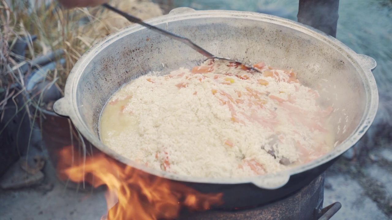 厨师用漏勺在锅里拌肉饭。视频素材