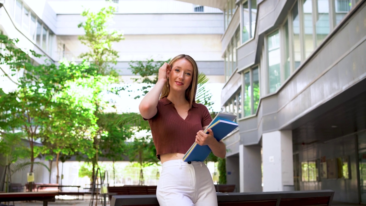 微笑的女学生拿着笔记本和活页夹视频素材