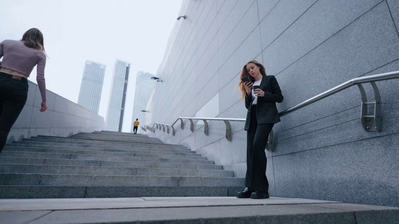 完整的画像美丽的商业女性在城市，女士正在打字短信在手机上视频素材