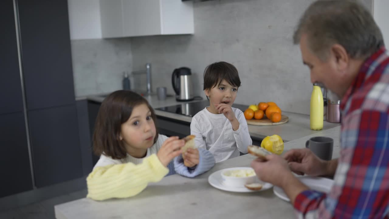 两个小孩正在吃爷爷做的三明治视频素材