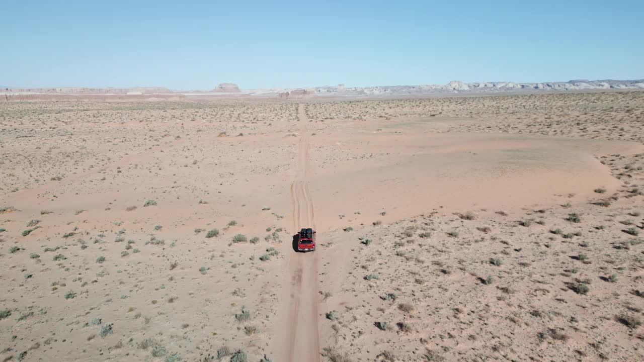 卡车行驶在犹他州沙漠中覆盖着沙子的道路上视频素材