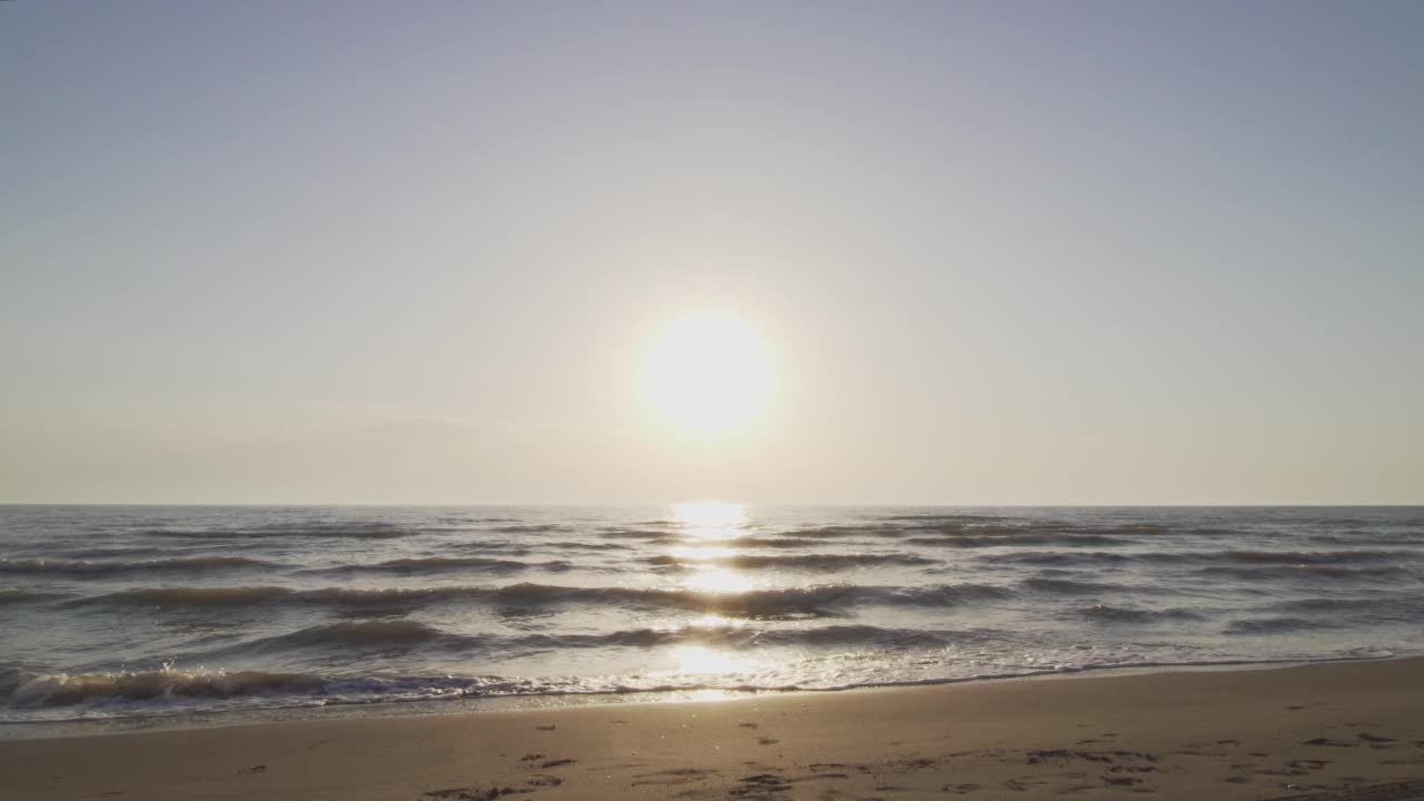 剪影夫妇在海滩上手牵着手，在海里跑向相机视频素材