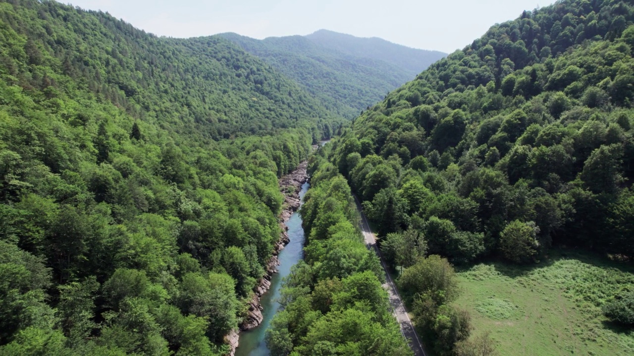 山间翡翠河，石质海岸和森林，溪流湍急，蜿蜒着晶莹剔透的山河。夏日阳光明媚的日子，无人机从上到下的视角视频素材