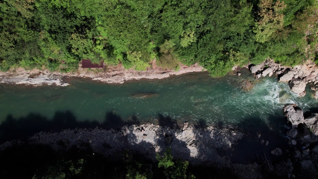 山间翡翠河，石质海岸和森林，溪流湍急，蜿蜒着晶莹剔透的山河。夏日阳光明媚的日子，无人机从上到下的视角视频下载