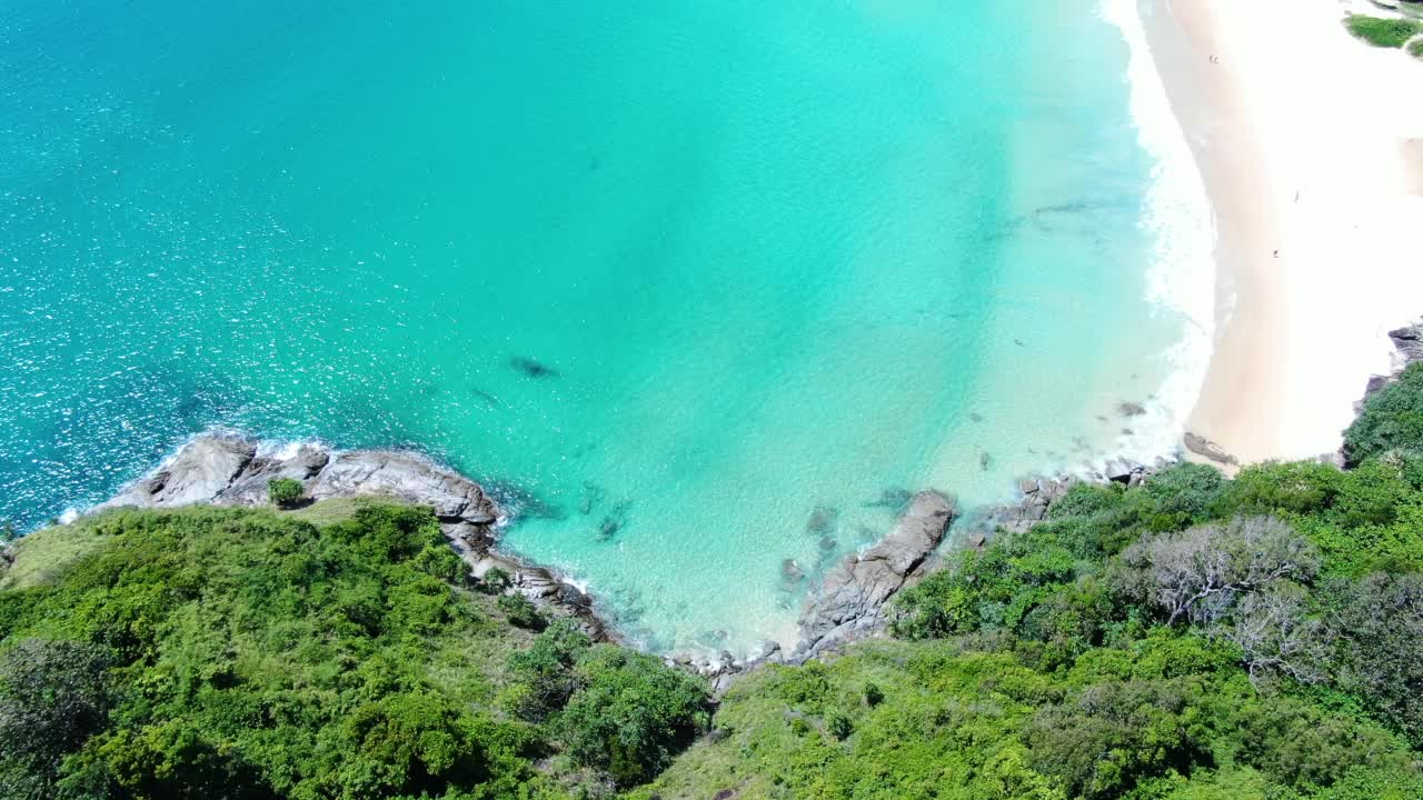 海浪大海岩石绿松石滚动缓慢碰撞岩石海岸线日落天堂岛。海滩沙子。视频素材