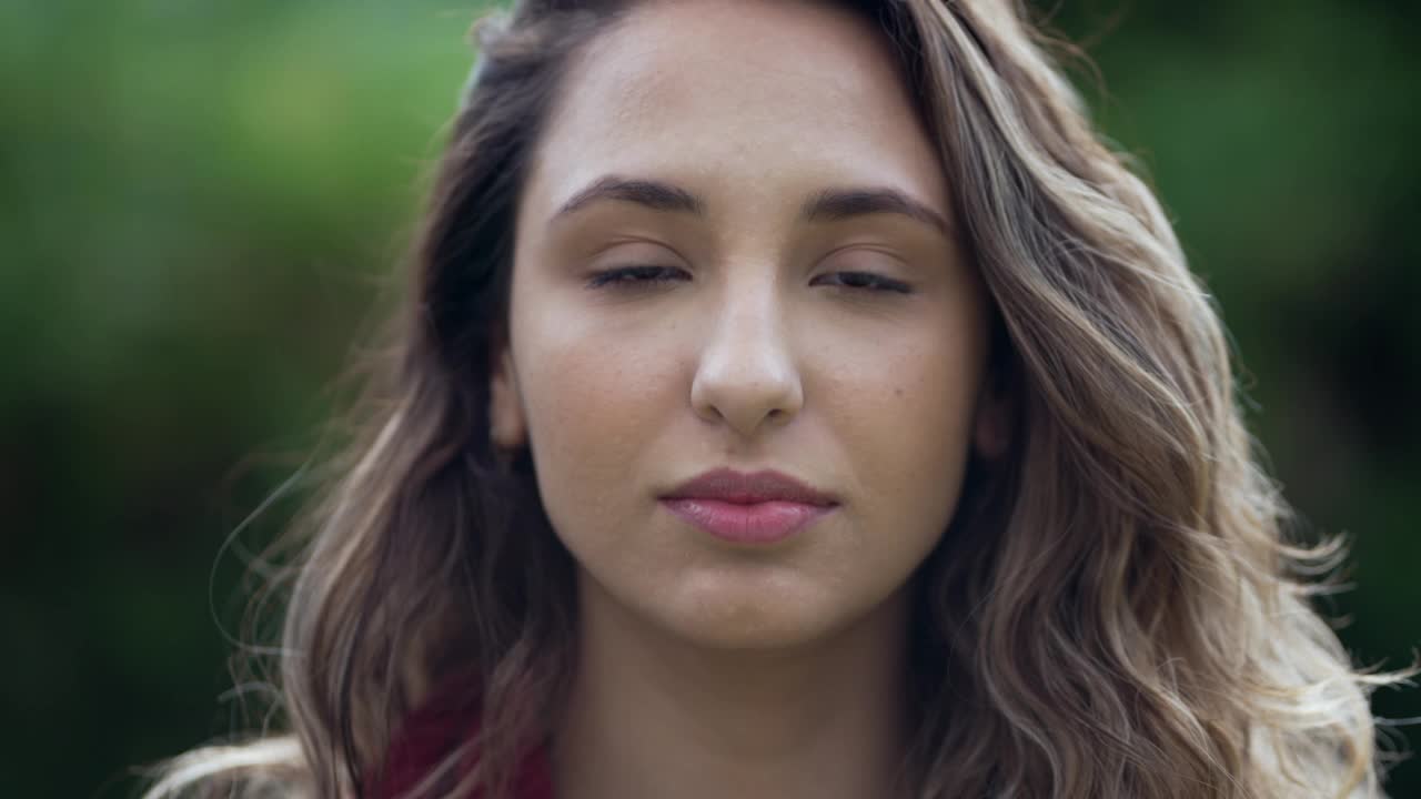 一个年轻的西班牙妇女看着相机的肖像。随意的南美拉丁女孩的脸特写站在公园的户外视频素材