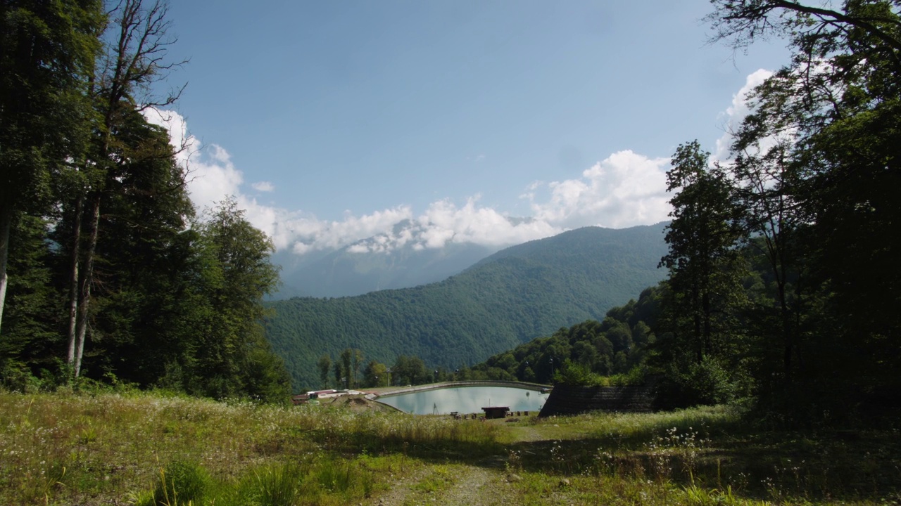 高大的松树勾勒出高加索山脉中湖泊的景色。位于山脉间池塘岸边的balneology度假村。自然呼吸治疗视频下载