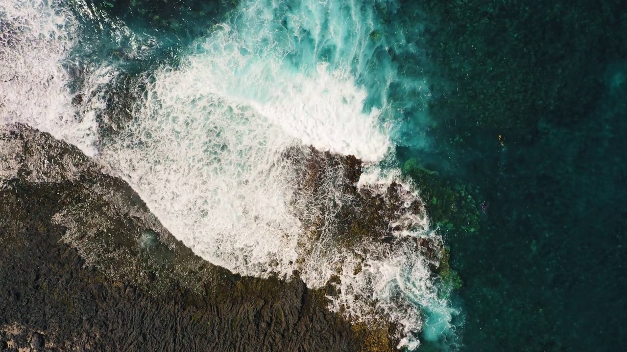 湛蓝透明清澈的水。白色的泡沫。风景如画的风景。天线。五彩缤纷的海水环绕着岩石嶙峋、风景秀丽的海岸线。海浪拍打着岩石。视频素材