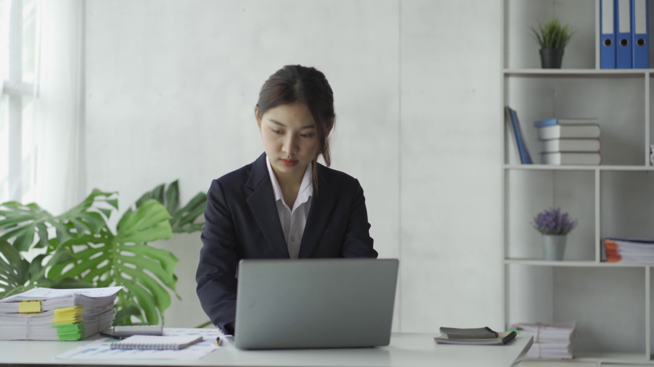 特写亚洲女商人使用计算器与税务计算器图表和图表报告的家庭收入和费用预算策划人。用笔记本电脑进行在线会议视频素材