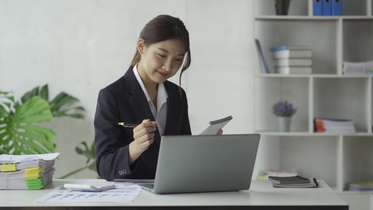 特写亚洲女商人使用计算器与税务计算器图表和图表报告的家庭收入和费用预算策划人。用笔记本电脑进行在线会议视频素材