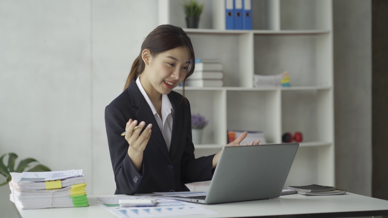 特写亚洲女商人使用计算器与税务计算器图表和图表报告的家庭收入和费用预算策划人。用笔记本电脑进行在线会议视频素材