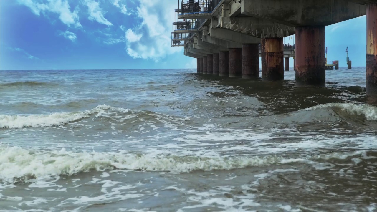 海岸。蓝色的天空。波浪撞击着桥视频素材