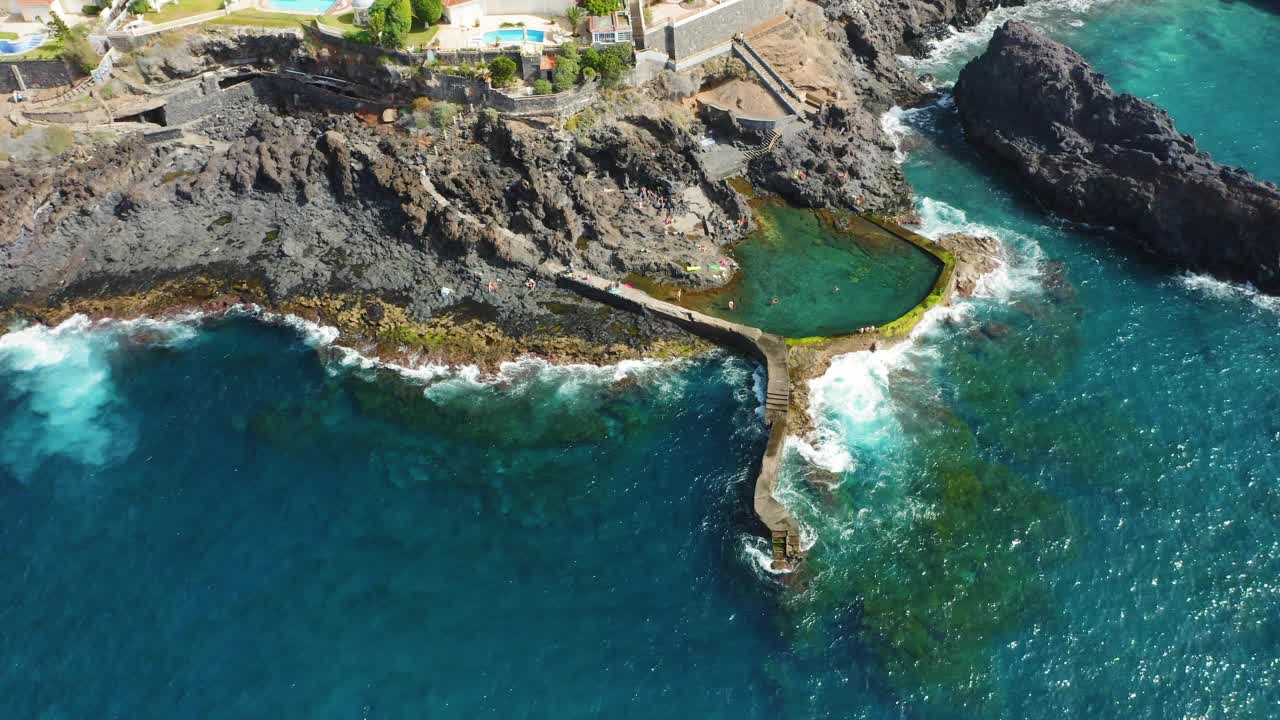 空中自上而下视图。人们在海洋天然游泳池游泳。特内里费岛火山岩形成的盆地。Piscina Acantilado de Los Gigantes。放松的好地方。视频素材