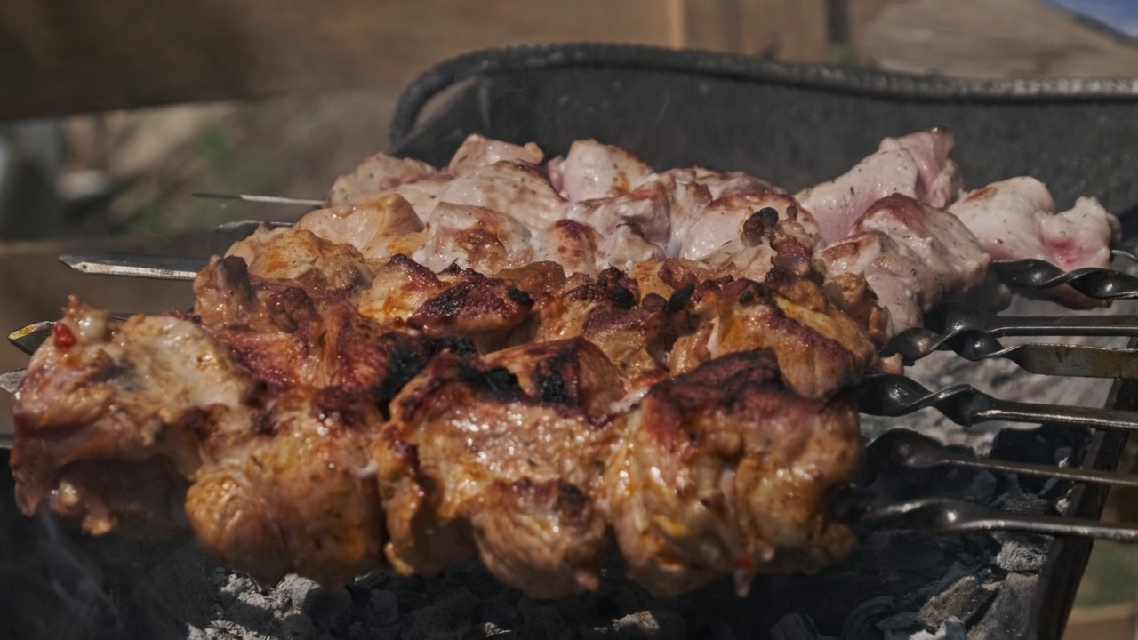 在大自然的烤架上烤烤肉，在煤上准备烤肉视频素材