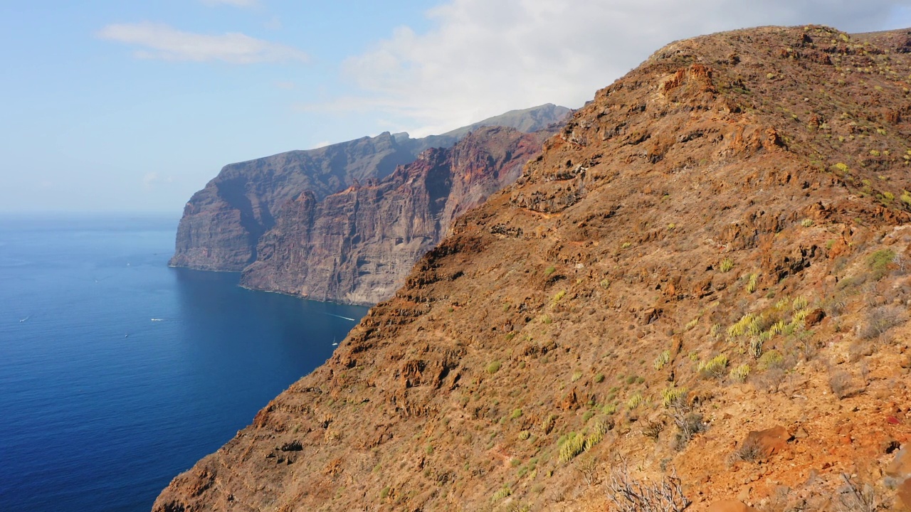 火山岛，冷却的熔岩形成了巨大的山脉，洛斯·吉甘特。这个度假胜地是圣地亚哥德尔特德，位于特内里费岛的加那利岛上。这块岩石高达500-800米。天线。视频素材