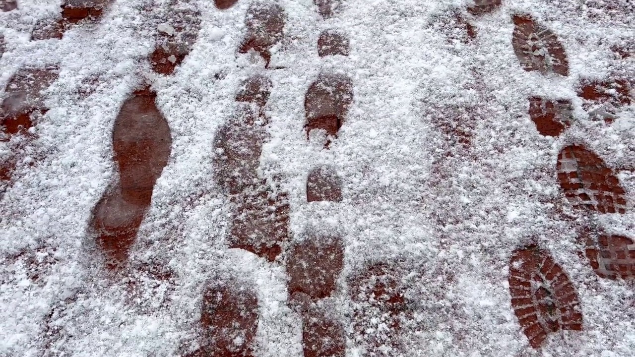 冬天积雪下结冰路面上的脚印。视频素材