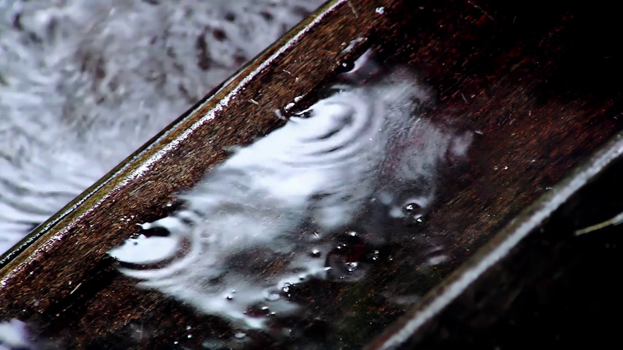 雨点落在木制甲板上，暴风雨天潮湿的木地板。近距离，4K分辨率。视频素材