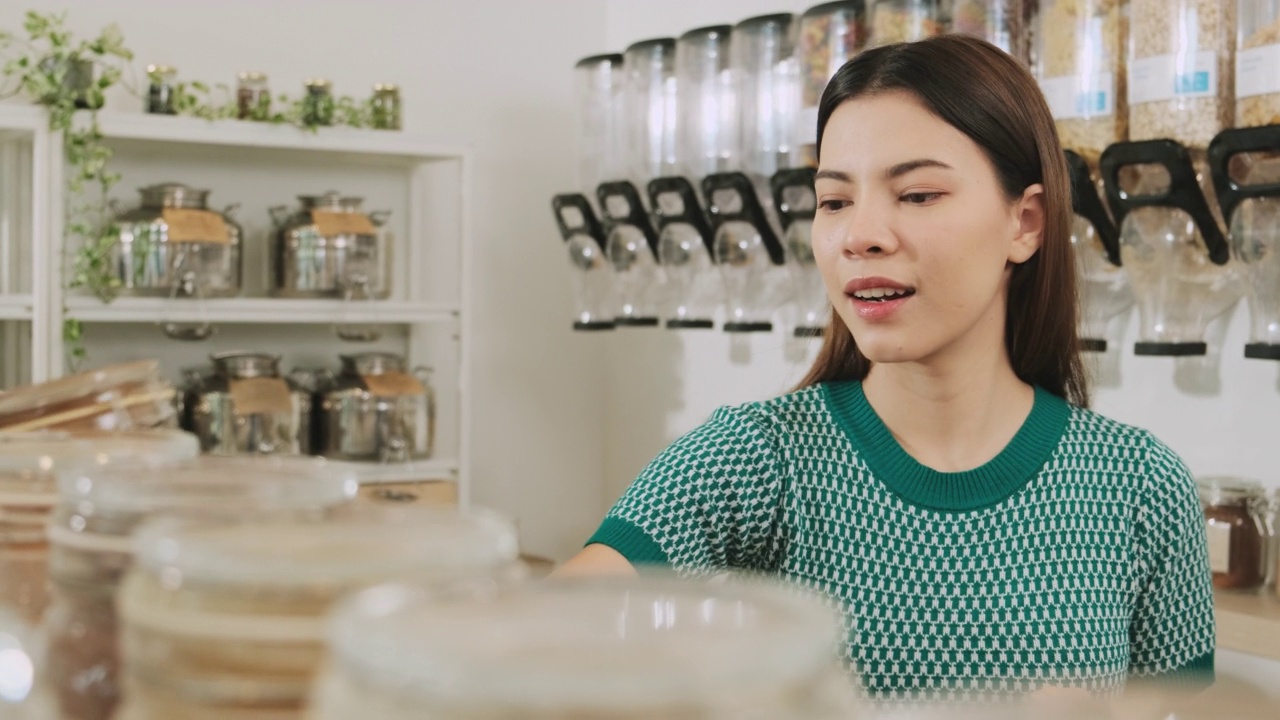 一名年轻女子在购物商店用可重复使用的袋子，零废物杂货。视频素材