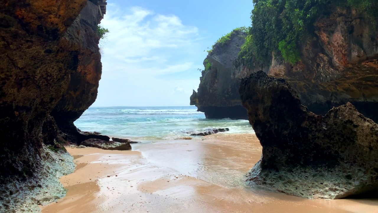 冲浪者利用Uluwatu洞穴到达巴厘岛的标志性海浪视频素材