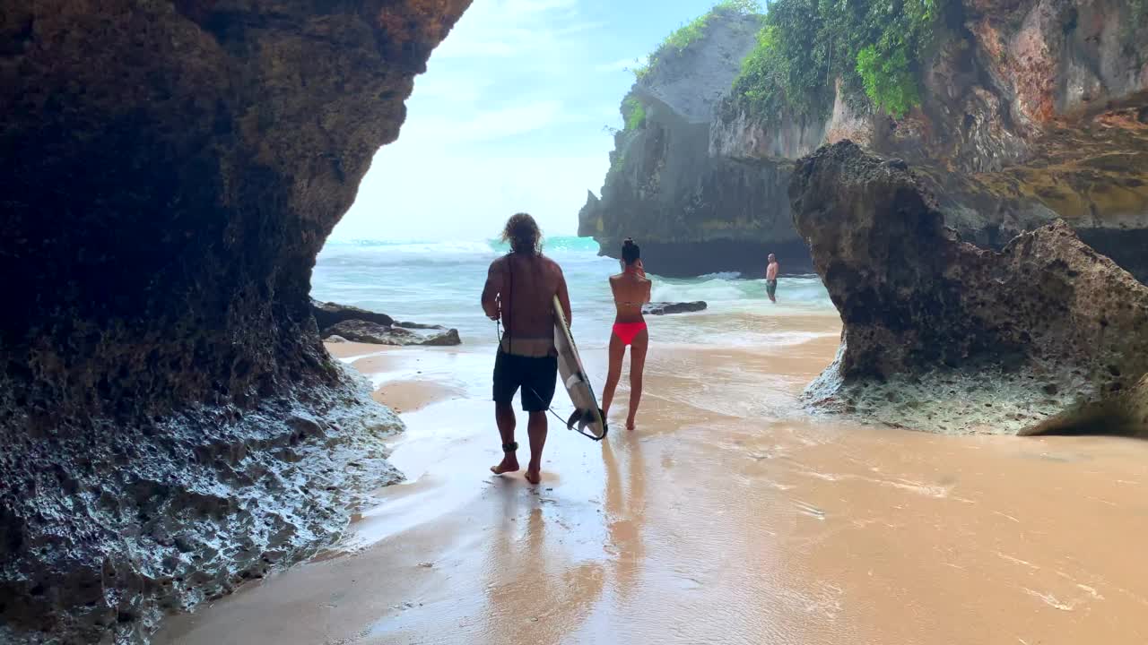 冲浪者的剪影正穿过Uluwatu洞穴，前往巴厘岛的标志性海浪视频素材