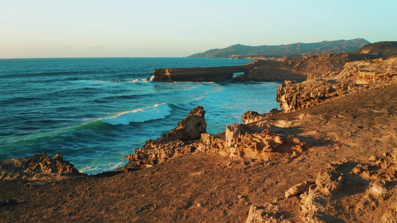 从砂岩上看日落海和陡坡海滩，火山岸线，温暖的夕阳。美丽的世界，大自然和户外旅行。Fuerteventura,金丝雀岛。西班牙。视频素材