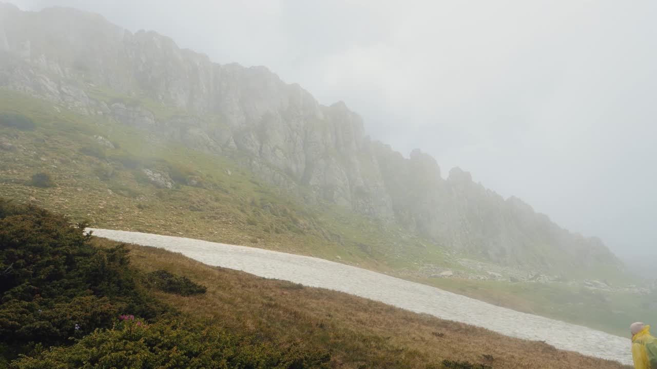 女人在多雨多雾的天气里爬山很困难。视频素材