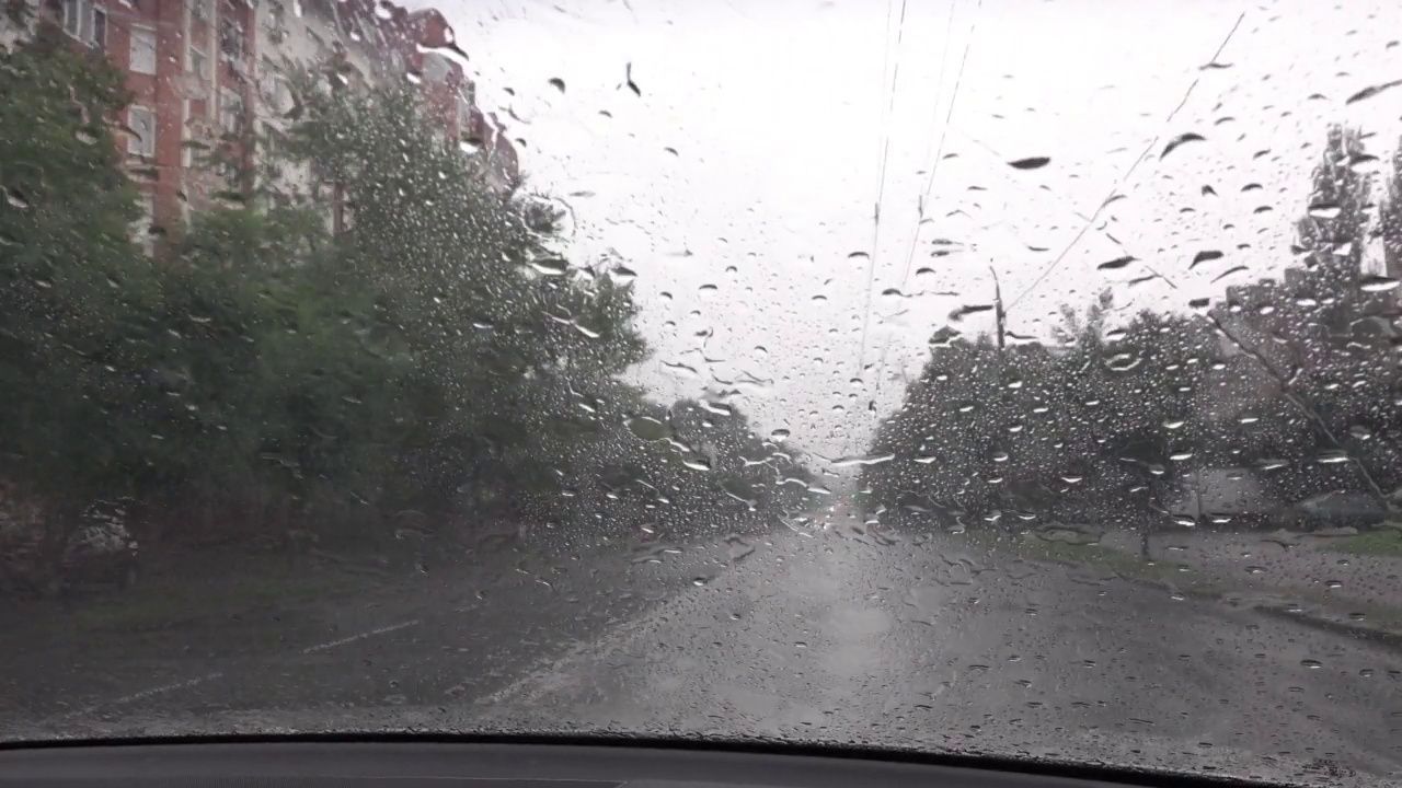 恶劣的天气，下雨天，雨水落在汽车挡风玻璃上，挡风玻璃雨刷工作，除雨，拍摄途中，下雨在街上视频素材