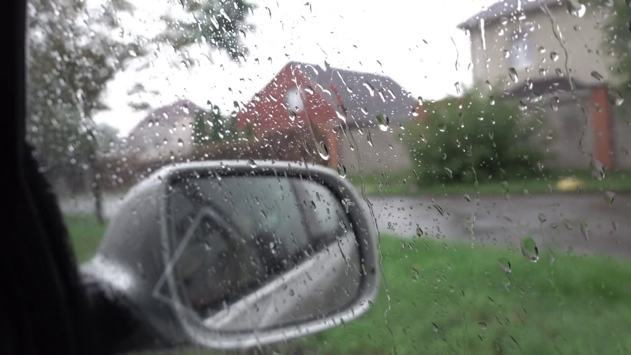 天气不好，下雨天，雨水落在汽车侧镜上，在路上拍戏，在街上下雨视频素材