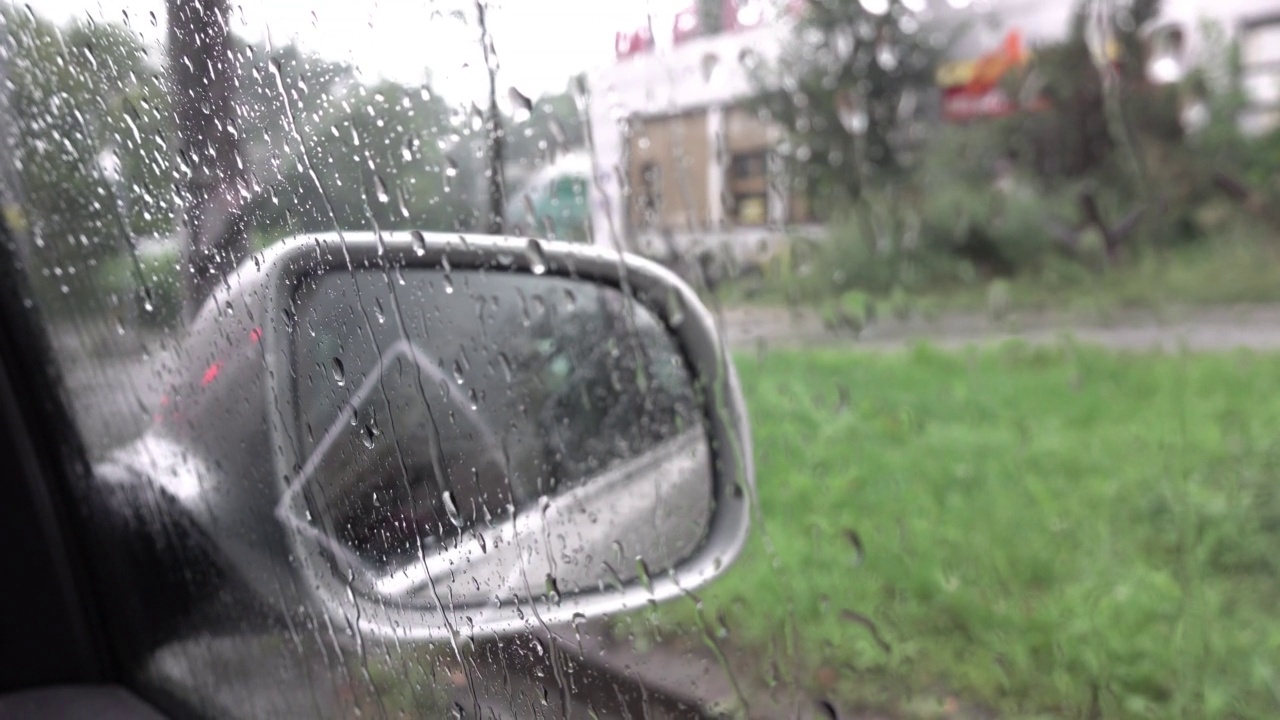 天气不好，下雨天，雨水落在汽车侧镜上，在路上拍戏，在街上下雨视频下载