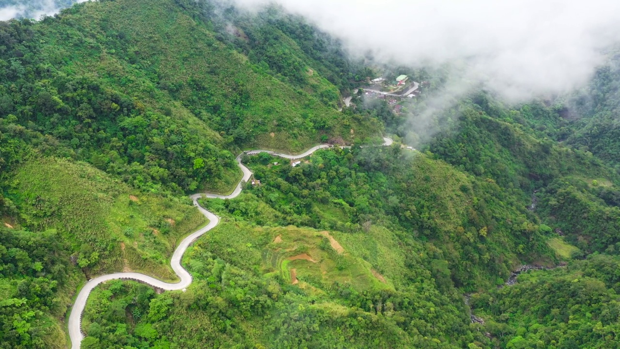 山路弯道，沿着山坡和丘陵，覆盖着绿色的森林和植被。菲律宾吕宋岛。视频素材