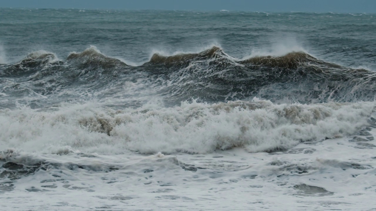 暴风雨的波。暴风雨中，带着泡沫和泥土的大浪拍打着海岸视频素材