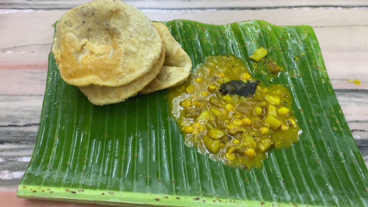 三种用精制小麦粉制成的puris或pooris配鹰嘴豆、咖喱或香蕉叶上的aloo Channa sabzi。视频素材