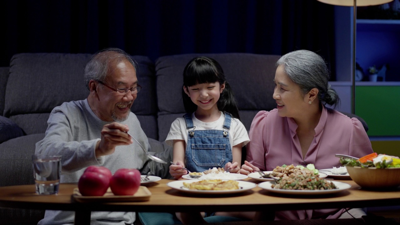 亚洲人幸福的家庭在餐桌上吃午餐，日本人在一起微笑。小孩子女儿喜欢吃爷爷奶奶的食物。幸福时光人们的生活方式观念。视频素材