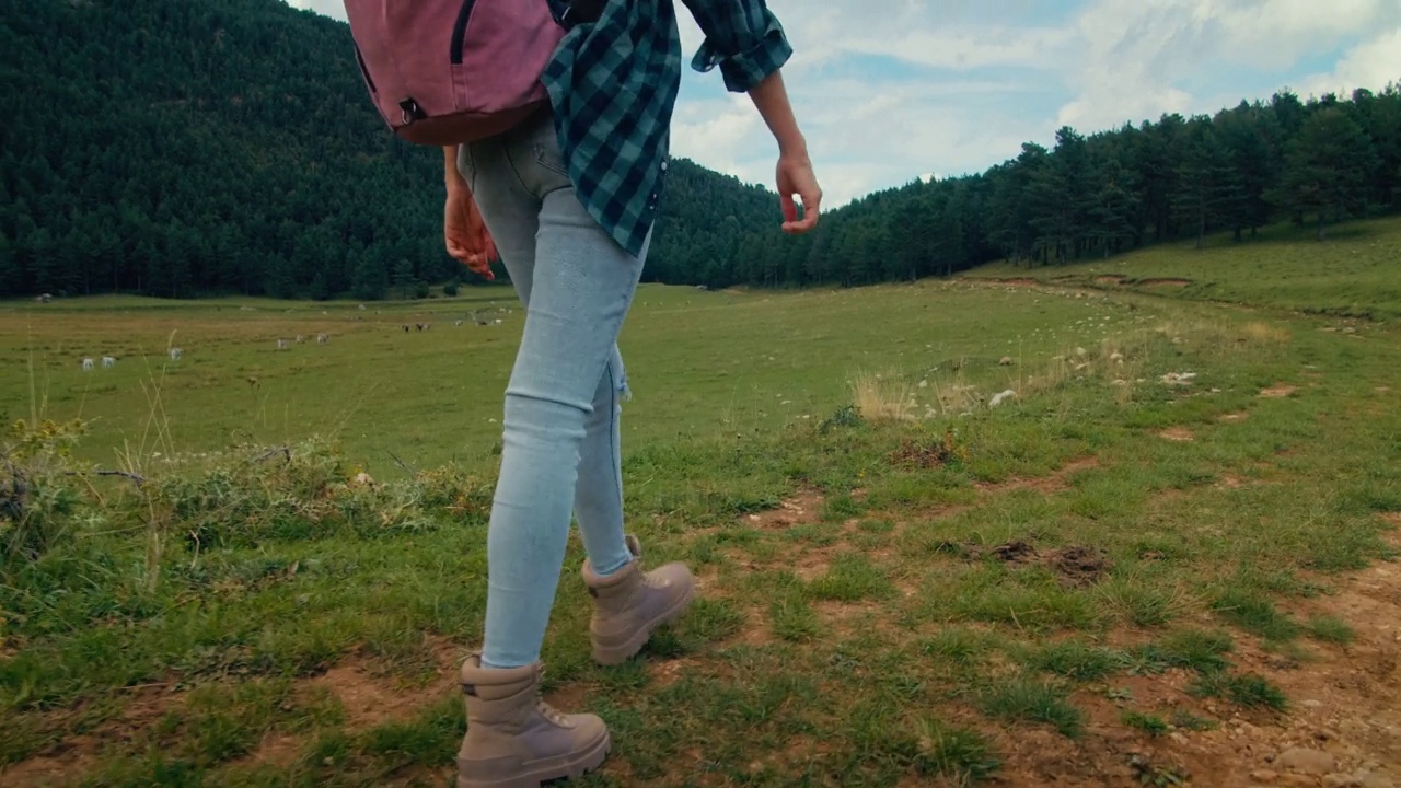 穿着徒步靴和背包的女人在山上徒步旅行冒险视频素材