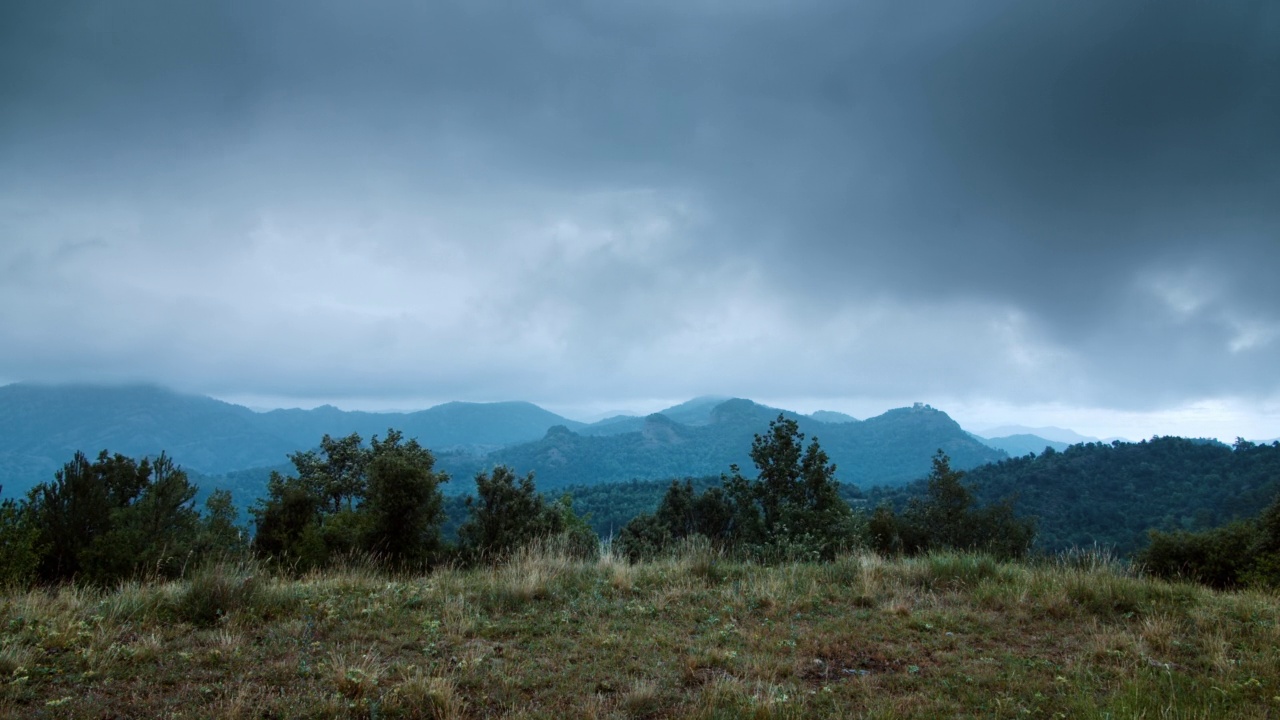 戏剧性的降雨时间在山景上流逝，乌云在天空移动视频素材