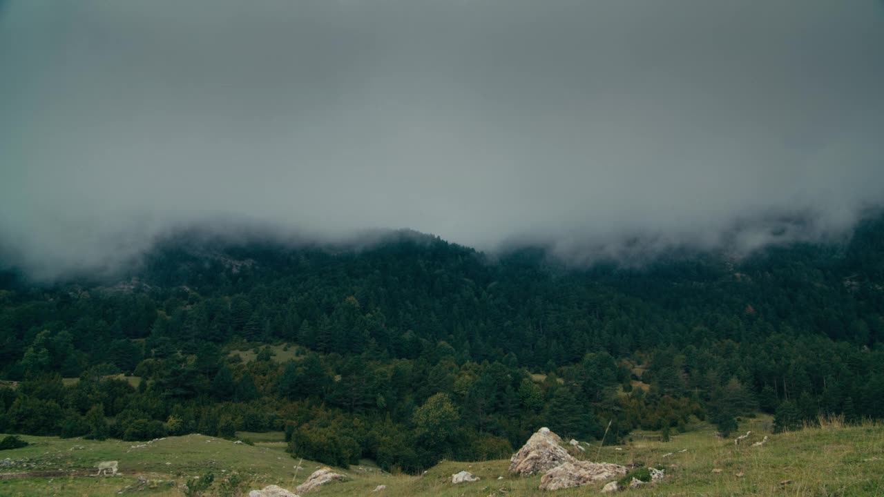 低低的雨云在时间流逝的天空中移动，在美丽的山景中视频素材