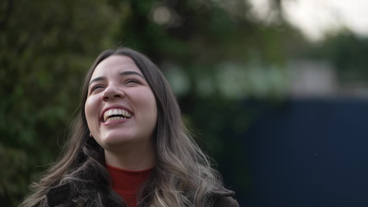 一个快乐随意的巴西西班牙裔年轻女子笑着和微笑的肖像脸特写站在户外视频素材