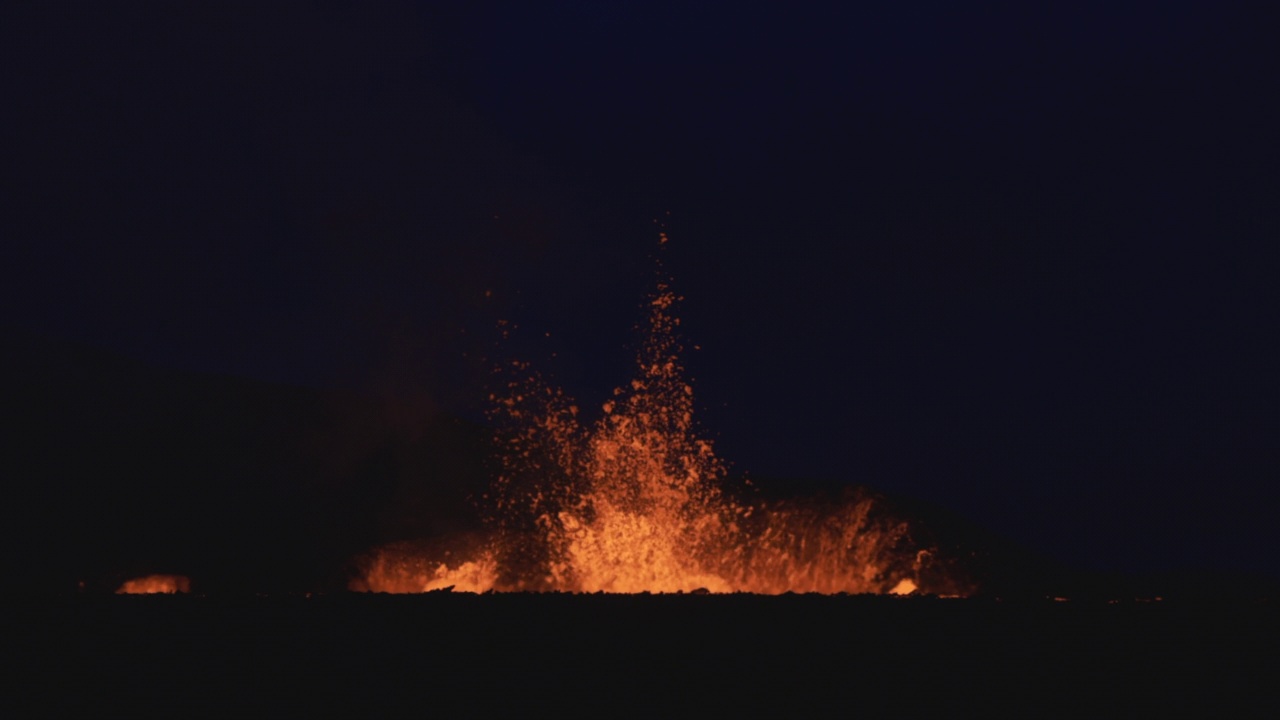 夜晚的慢动作视频显示熔岩从冰岛猛烈的火山喷发中喷射到空中视频素材