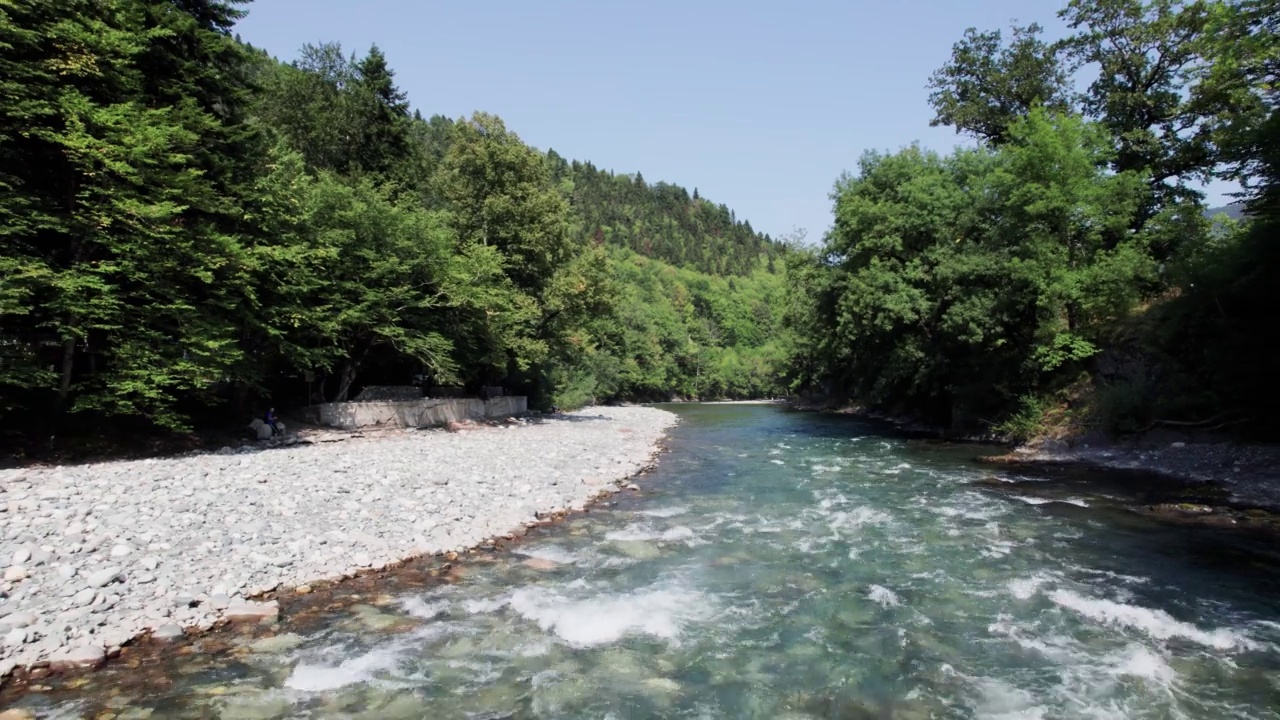 山间翡翠河，石质海岸和森林，溪流湍急，蜿蜒着晶莹剔透的山河。夏日阳光明媚的日子，无人机从上到下的视角视频下载