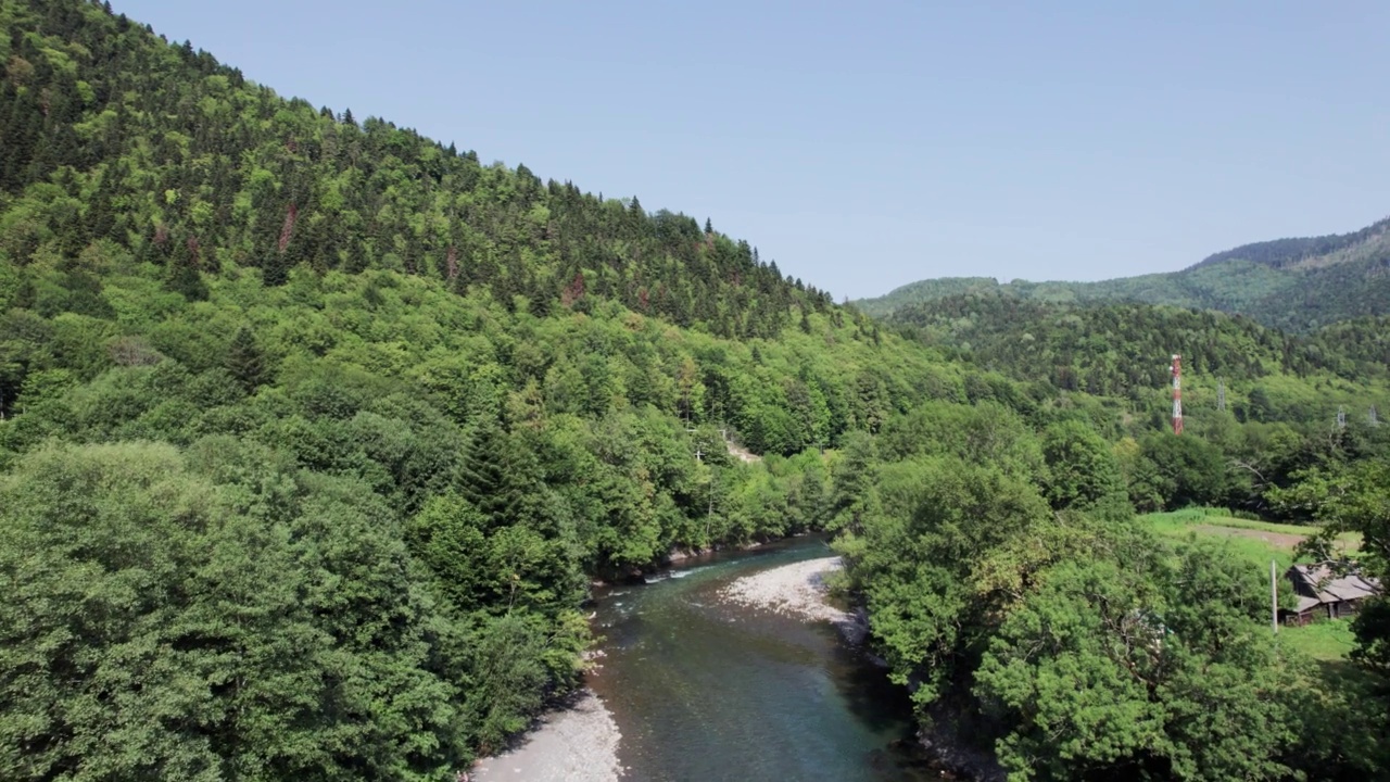 山间翡翠河，石质海岸和森林，溪流湍急，蜿蜒着晶莹剔透的山河。夏日阳光明媚的日子，无人机从上到下的视角视频素材