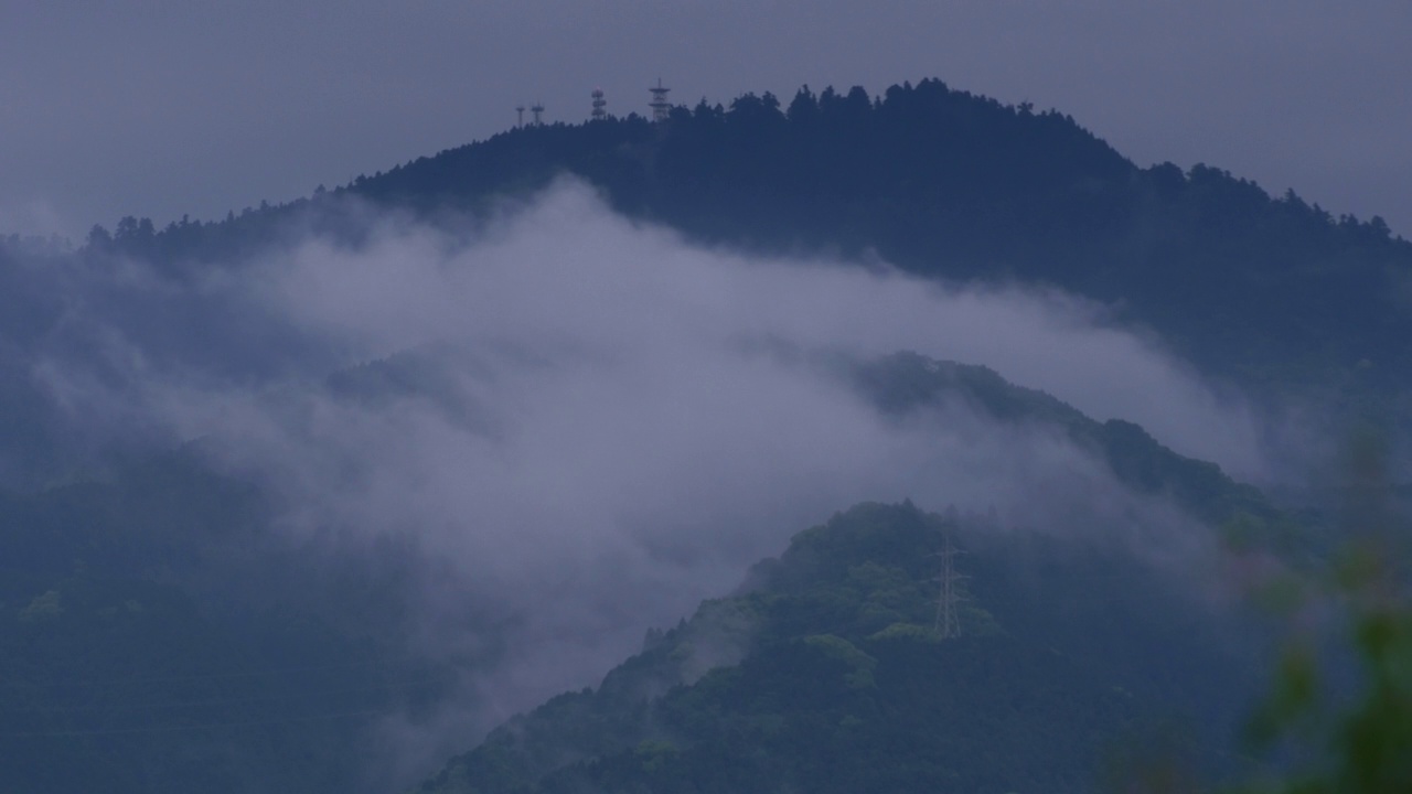 雾霾笼罩着山峦和田野。雨云在山上迅速移动。黑暗的cloudscape。视频素材