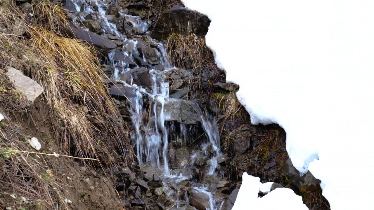雪山中的河流和岩石。冬天的场景。自然有雪。瀑布河视频素材
