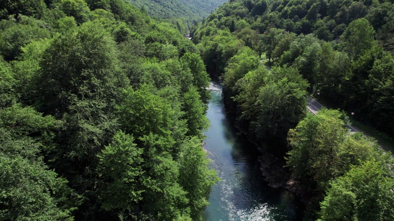 山间翡翠河，石质海岸和森林，溪流湍急，蜿蜒着晶莹剔透的山河。夏日阳光明媚的日子，无人机从上到下的视角视频下载