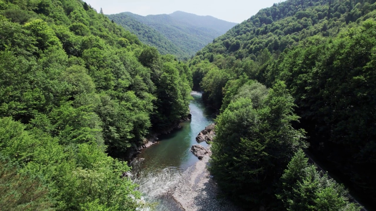 山间翡翠河，石质海岸和森林，溪流湍急，蜿蜒着晶莹剔透的山河。夏日阳光明媚的日子，无人机从上到下的视角视频素材