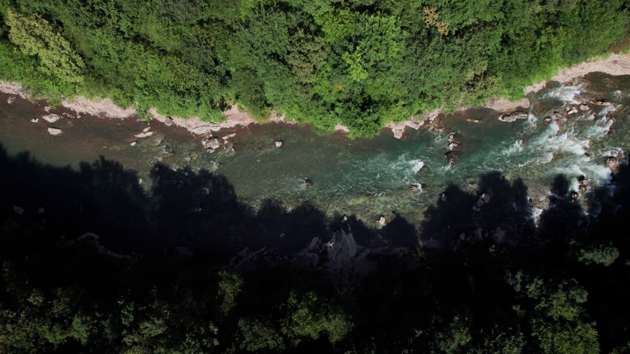 山间翡翠河，石质海岸和森林，溪流湍急，蜿蜒着晶莹剔透的山河。夏日阳光明媚的日子，无人机从上到下的视角视频素材