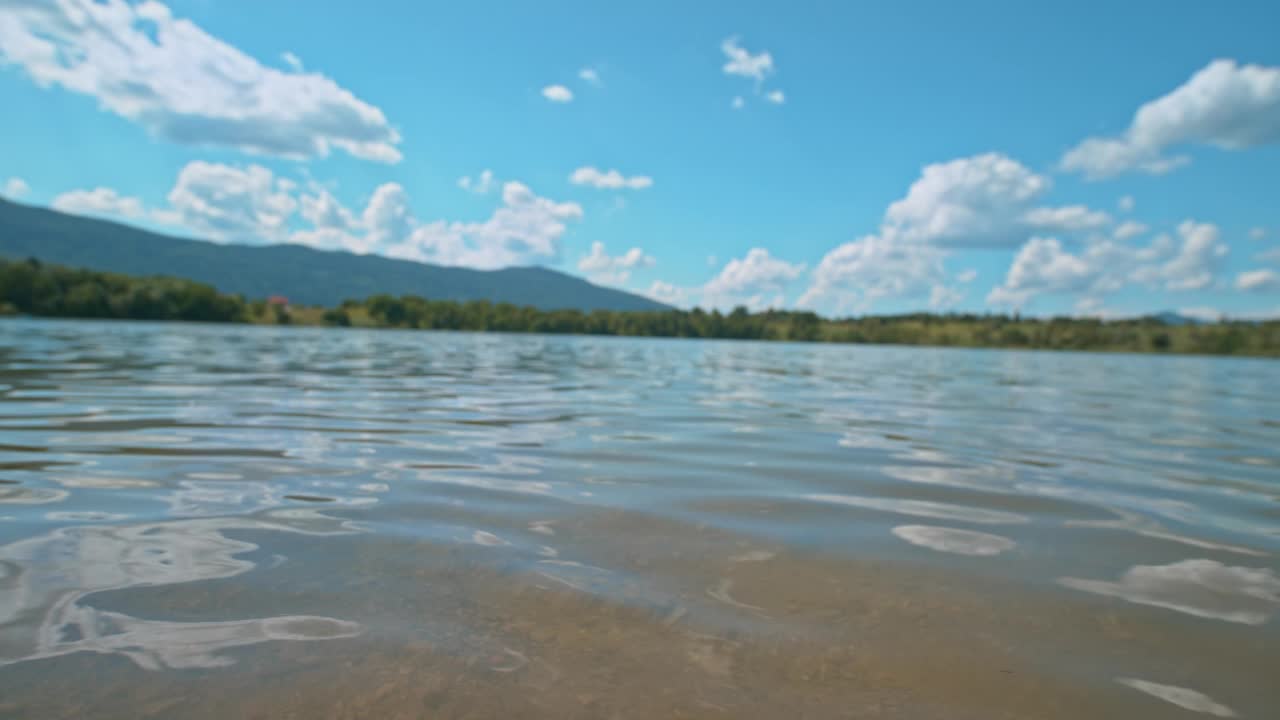 年轻人在阳光下跑进湖里视频素材