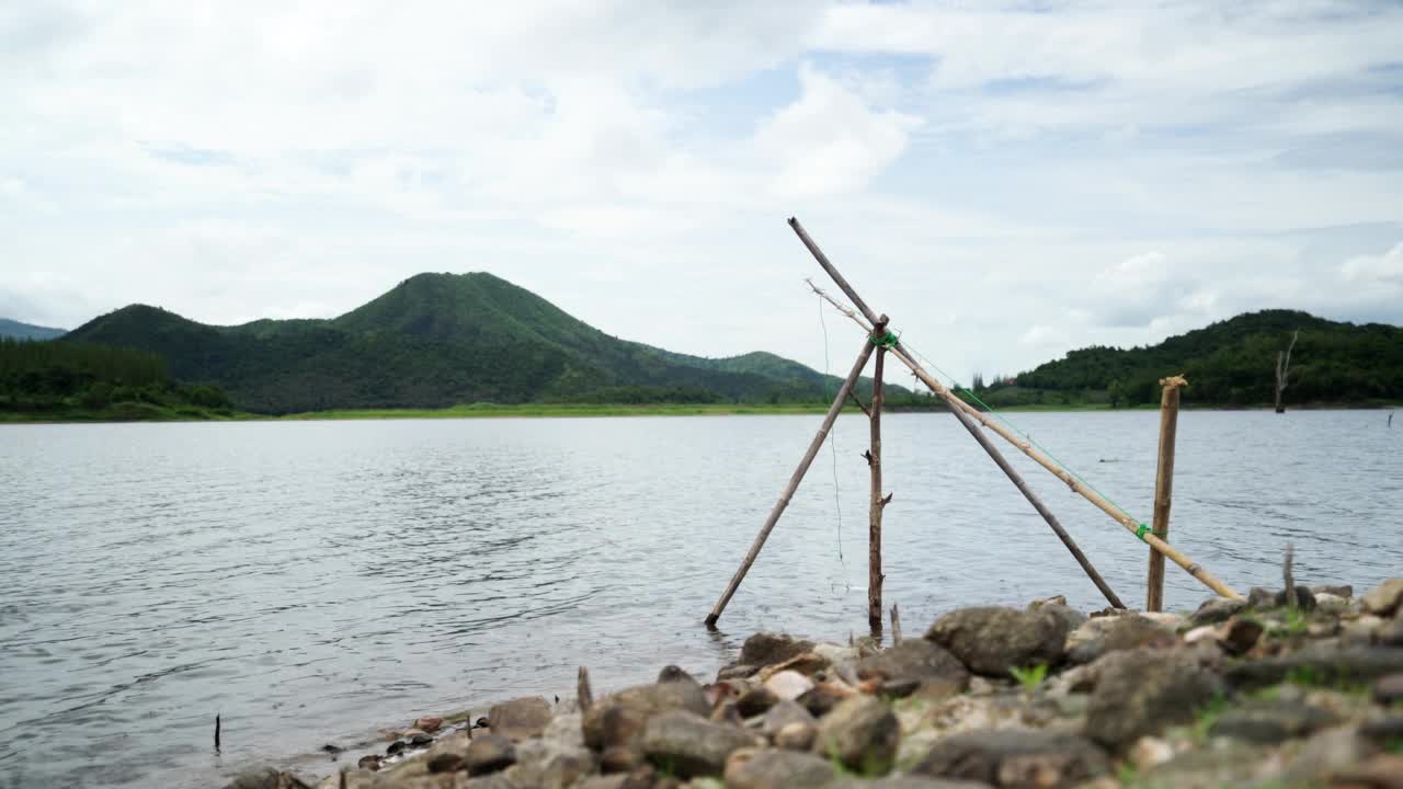 在背景中山谷中的湖边钓鱼视频素材