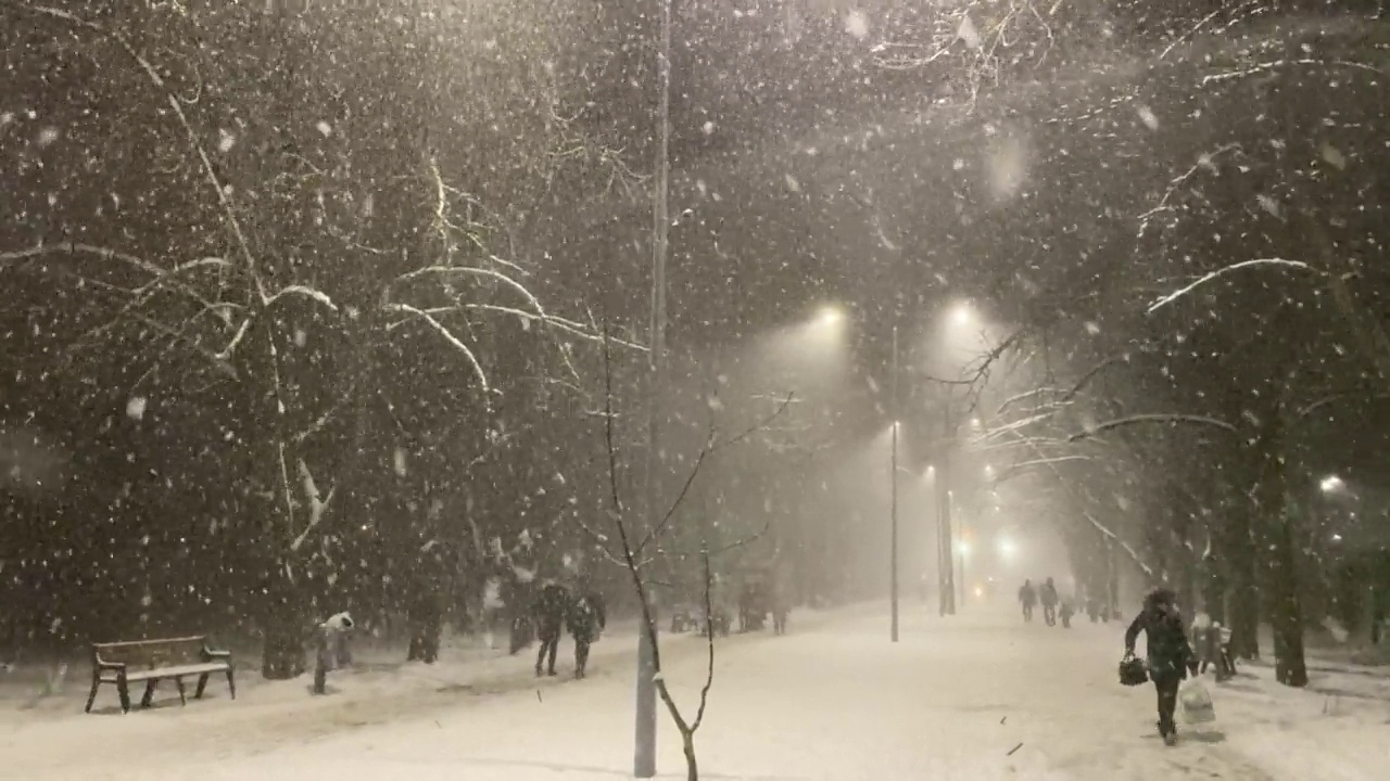 沉重的暴雪。人们走在下雪的冬天街道上。大雪视频素材