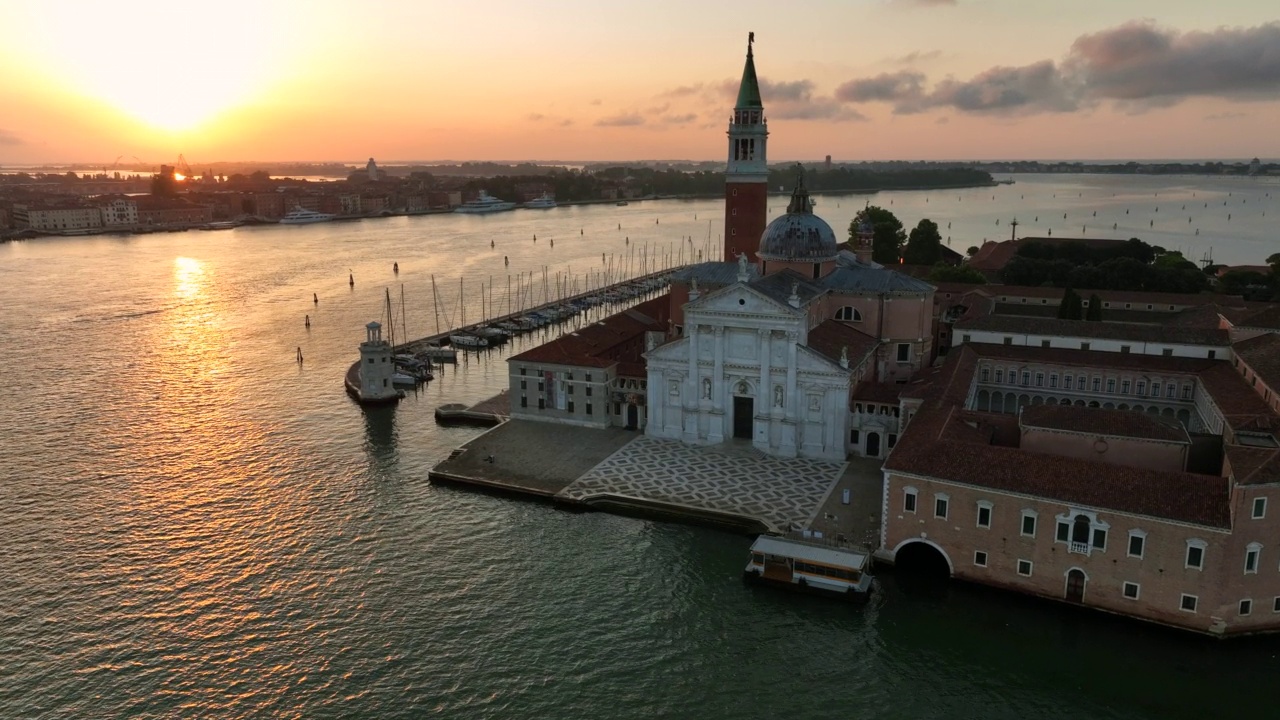 日出和泻湖蓝色水域之间的船只往来，对面是圣马可广场(Piazza SAN Marco)，威尼斯岛上一座16世纪本笃会教堂视频素材