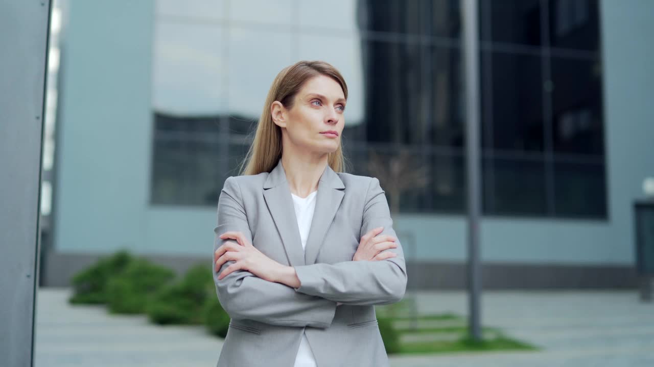 肖像吸引严肃自信的商业女雇员看着相机。白人女性金发中年工人站在城市办公楼外面的室外视频素材